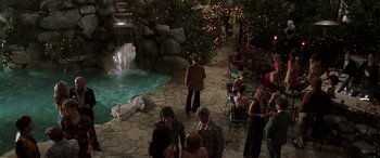 Movie still from “Confessions of a Dangerous Mind” (2002), directed by George Clooney – A group of people standing around a waterfall; Extreme Wide shot, High angle
