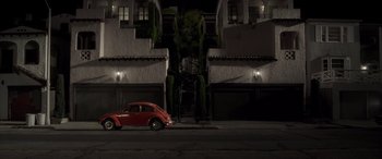 Movie still from “Confessions of a Dangerous Mind” (2002), directed by George Clooney – A red car parked on the side of the street; Extreme Wide shot, High angle