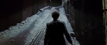 Movie still from “Confessions of a Dangerous Mind” (2002), directed by George Clooney – A man in a suit walking down a street; Wide shot, Low angle