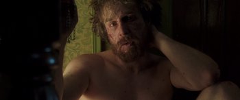 Movie still from “Confessions of a Dangerous Mind” (2002), directed by George Clooney – A man with a beard is looking into the mirror; Close Up shot, High angle