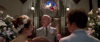 Movie still from “Confessions of a Dangerous Mind” (2002), directed by George Clooney – A man in a suit is standing in front of two other people; Medium shot, Low angle