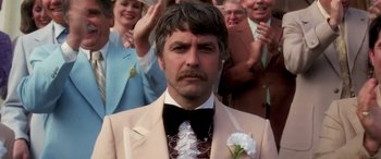 Movie still from “Confessions of a Dangerous Mind” (2002), directed by George Clooney – A man in a suit with a flower in his lapel; Close Up shot, Low angle