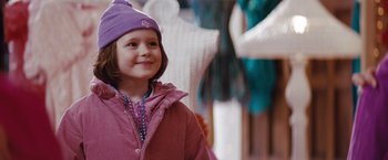 Movie still from “Confessions of a Shopaholic” (2009), directed by P.J. Hogan – A little girl wearing a purple hat and a pink jacket; Medium shot, Over the shoulder angle