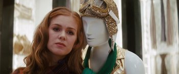 Movie still from “Confessions of a Shopaholic” (2009), directed by P.J. Hogan – A woman standing next to a mannequin wearing a helmet; Close Up shot, Over the shoulder angle