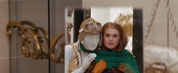 Movie still from “Confessions of a Shopaholic” (2009), directed by P.J. Hogan – A woman is holding onto a mannequin in a dress shop window; Medium shot, Over the shoulder angle