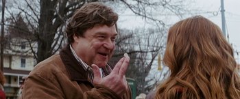 Movie still from “Confessions of a Shopaholic” (2009), directed by P.J. Hogan – A man holding a piece of food in his hand; Close Up shot, Over the shoulder angle