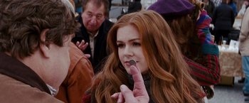 Movie still from “Confessions of a Shopaholic” (2009), directed by P.J. Hogan – A woman with red hair is holding a piece of chocolate in her mouth; Close Up shot, Over the shoulder angle