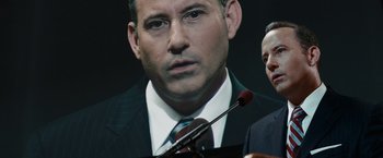 Movie still from “Confessions of a Shopaholic” (2009), directed by P.J. Hogan – A person wearing a suit and tie; Close Up shot, Over the shoulder angle