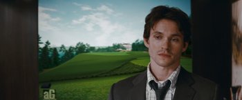 Movie still from “Confessions of a Shopaholic” (2009), directed by P.J. Hogan – A man wearing a suit and tie standing in front of a field; Close Up shot, Over the shoulder angle