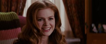 Movie still from “Confessions of a Shopaholic” (2009), directed by P.J. Hogan – A person with long red hair smiling; Close Up shot, Over the shoulder angle