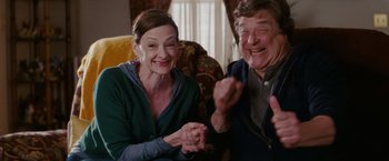 Movie still from “Confessions of a Shopaholic” (2009), directed by P.J. Hogan – A man and a woman sitting next to each other on a couch; Medium shot, Low angle