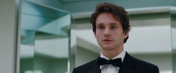 Movie still from “Confessions of a Shopaholic” (2009), directed by P.J. Hogan – A man in a suit and bow tie looking at the camera; Close Up shot, Over the shoulder angle