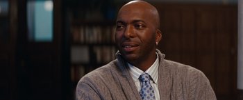 Movie still from “Confessions of a Shopaholic” (2009), directed by P.J. Hogan – A man wearing a sweater and a blue tie; Close Up shot, Over the shoulder angle