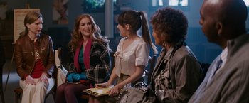 Movie still from “Confessions of a Shopaholic” (2009), directed by P.J. Hogan – A group of women sitting next to each other on a couch; Medium shot, Over the shoulder angle