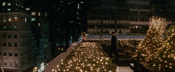Movie still from “Confessions of a Shopaholic” (2009), directed by P.J. Hogan – A man and a woman standing next to a row of lit candles; Extreme Wide shot, High angle