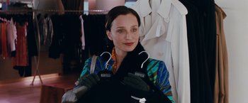 Movie still from “Confessions of a Shopaholic” (2009), directed by P.J. Hogan – A woman holding a pair of headphones in her hands; Medium shot, Over the shoulder angle