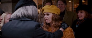 Movie still from “Confessions of a Shopaholic” (2009), directed by P.J. Hogan – A woman wearing a yellow hat and a leather jacket; Medium shot, Over the shoulder angle