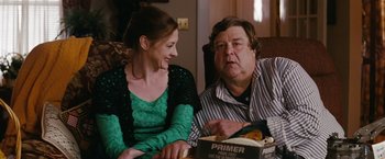 Movie still from “Confessions of a Shopaholic” (2009), directed by P.J. Hogan – A man and a woman sitting next to each other on a couch; Medium shot, Over the shoulder angle