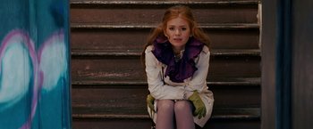 Movie still from “Confessions of a Shopaholic” (2009), directed by P.J. Hogan – A woman sitting on the steps of a building; Medium shot, Over the shoulder angle