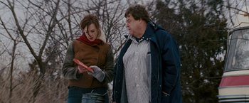 Movie still from “Confessions of a Shopaholic” (2009), directed by P.J. Hogan – A woman and a man standing next to each other holding an object; Medium shot, Over the shoulder angle