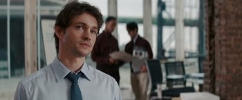 Movie still from “Confessions of a Shopaholic” (2009), directed by P.J. Hogan – A man in a dress shirt and tie in an office setting; Close Up shot, Over the shoulder angle