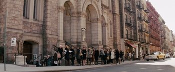 Movie still from “Confessions of a Shopaholic” (2009), directed by P.J. Hogan – A group of people standing on the side of a building; Extreme Wide shot, High angle