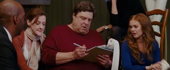 Movie still from “Confessions of a Shopaholic” (2009), directed by P.J. Hogan – An older man writing on a notepad while holding a pen; Close Up shot, Low angle