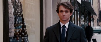 Movie still from “Confessions of a Shopaholic” (2009), directed by P.J. Hogan – A man wearing a suit and tie standing outside; Close Up shot, Over the shoulder angle