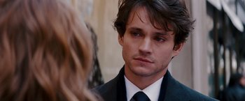 Movie still from “Confessions of a Shopaholic” (2009), directed by P.J. Hogan – A person wearing a suit and tie; Close Up shot, Over the shoulder angle