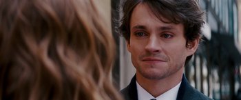Movie still from “Confessions of a Shopaholic” (2009), directed by P.J. Hogan – A person wearing a suit and tie; Close Up shot, Over the shoulder angle