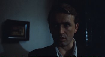 Movie still from “Confidence” (1980), directed by István Szabó – A person wearing a suit and tie; Close Up shot, Low angle