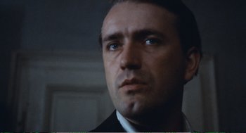 Movie still from “Confidence” (1980), directed by István Szabó – A person wearing a suit and tie; Close Up shot, Low angle