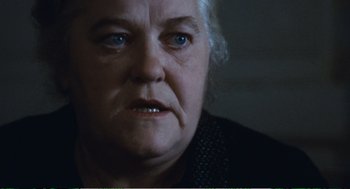 Movie still from “Confidence” (1980), directed by István Szabó – An older woman with a frowning look on her face; Close Up shot, Low angle