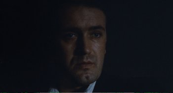 Movie still from “Confidence” (1980), directed by István Szabó – A person wearing a suit and tie; Close Up shot, Low angle