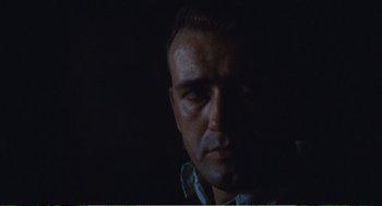 Movie still from “Confidence” (1980), directed by István Szabó – A person in a dark room; Close Up shot, Low angle