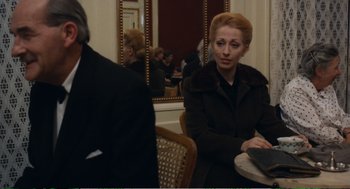 Movie still from “Confidence” (1980), directed by István Szabó – A woman sitting in front of a mirror at a table; Medium shot, Over the shoulder angle