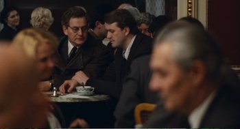 Movie still from “Confidence” (1980), directed by István Szabó – A group of men sitting at a table with food; Medium shot, Over the shoulder angle