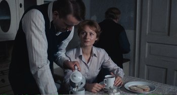 Movie still from “Confidence” (1980), directed by István Szabó – A man and a woman at a table with cups; Medium shot, Over the shoulder angle