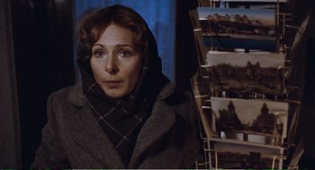 Movie still from “Confidence” (1980), directed by István Szabó – A woman wearing a gray coat and a plaid scarf; Close Up shot, Over the shoulder angle