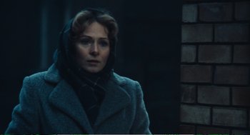 Movie still from “Confidence” (1980), directed by István Szabó – A woman wearing a gray coat and a black scarf; Close Up shot, Over the shoulder angle