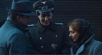 Movie still from “Confidence” (1980), directed by István Szabó – Two men and a woman in uniform talking to each other; Medium shot, Over the shoulder angle