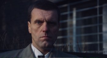 Movie still from “Confidence” (1980), directed by István Szabó – A person wearing a suit and tie; Close Up shot, Low angle