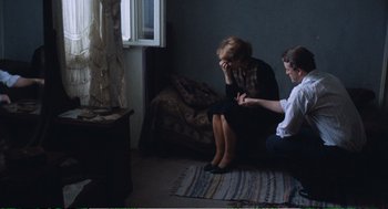 Movie still from “Confidence” (1980), directed by István Szabó – A woman sitting next to a man in front of a window; Medium shot, High angle