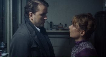 Movie still from “Confidence” (1980), directed by István Szabó – A man and a woman standing next to each other in a room; Close Up shot, Over the shoulder angle