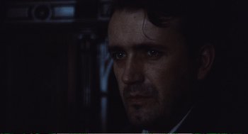 Movie still from “Confidence” (1980), directed by István Szabó – A person wearing a suit and tie; Close Up shot, Low angle