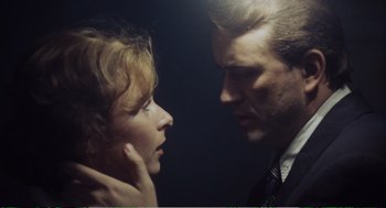 Movie still from “Confidence” (1980), directed by István Szabó – A man and a woman looking at each other in the dark; Close Up shot, Low angle