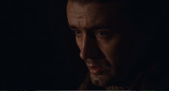 Movie still from “Confidence” (1980), directed by István Szabó – A man's face in the dark; Close Up shot, Low angle