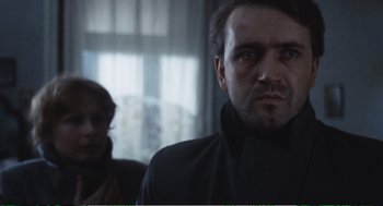 Movie still from “Confidence” (1980), directed by István Szabó – A person wearing a suit and tie; Close Up shot, Over the shoulder angle