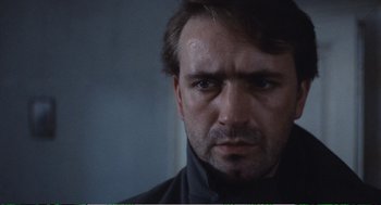 Movie still from “Confidence” (1980), directed by István Szabó – A person wearing a black jacket; Close Up shot, Low angle