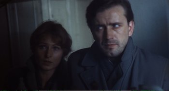Movie still from “Confidence” (1980), directed by István Szabó – A man and a woman standing next to each other in a room; Close Up shot, Over the shoulder angle